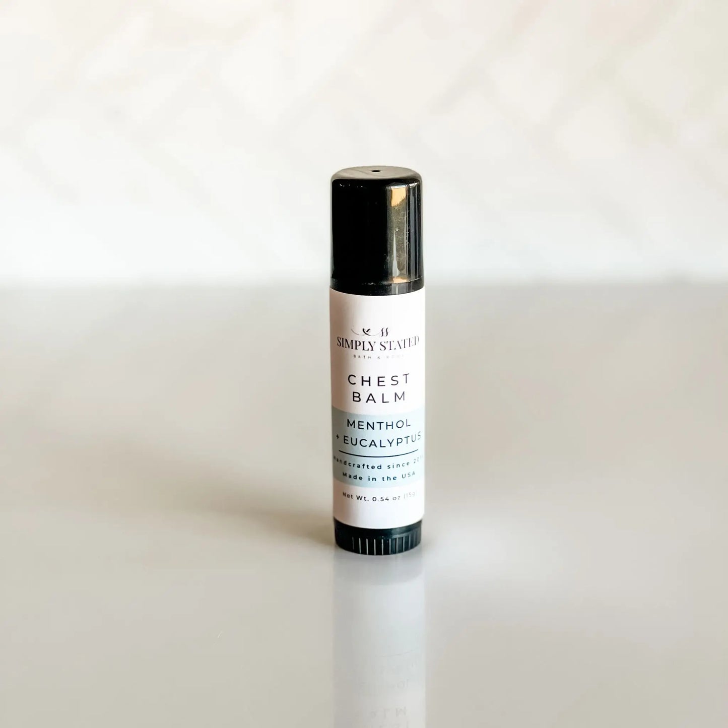 Simply Stated Bath & Body Menthol Eucalyptus Chest Balm stick standing upright on a light surface.