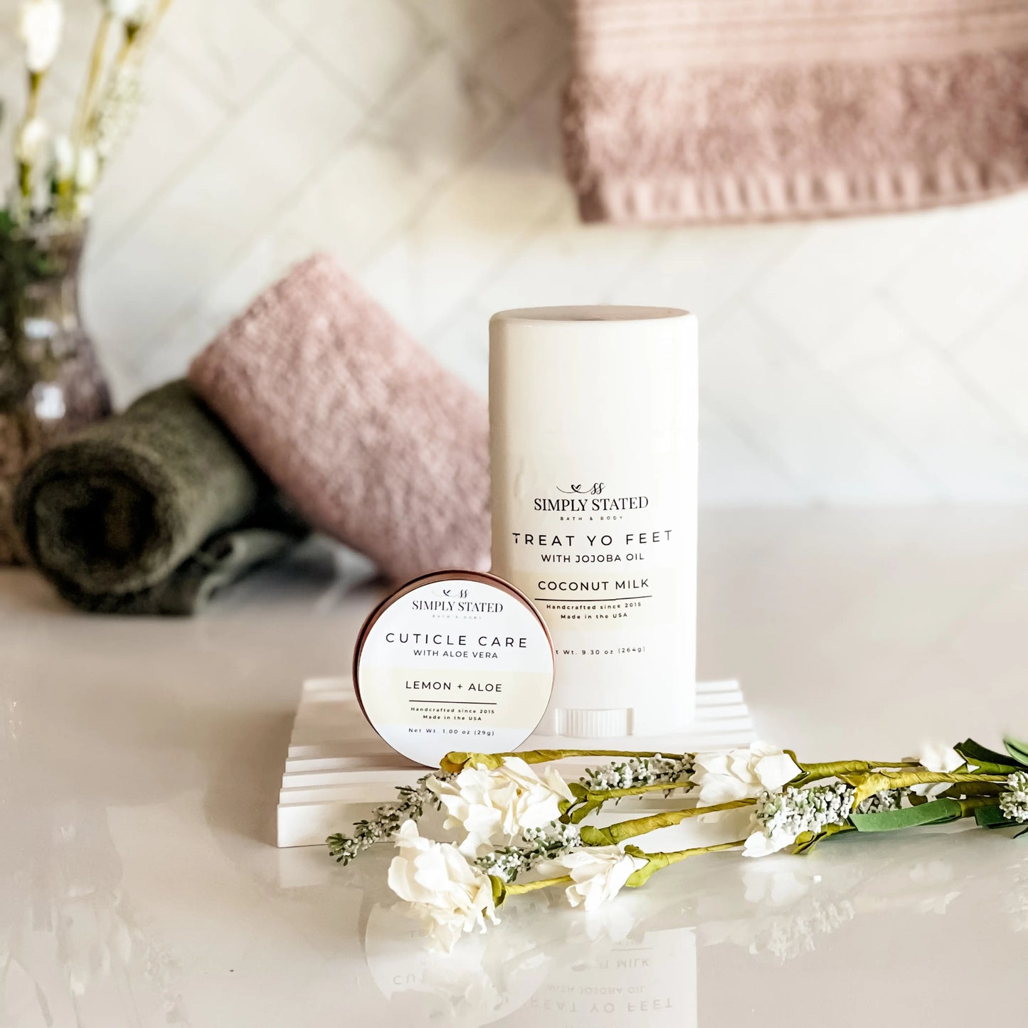 Coconut Milk Treat Yo Feet and Lemon + Aloe Cuticle Care by Simply Stated Bath & Body, styled with towels and flowers
