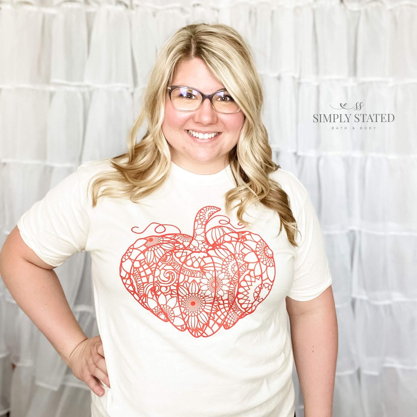 Graphic T-Shirt in a cream, natural color. The design is a large pumpkin with whimsy sunflowers for the inside pattern.