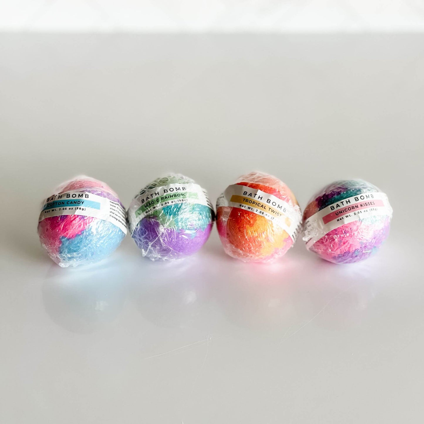 Kids Bath Bombs wrapped individually: Cotton Candy, Magic Rainbow, Tropical Twist, and Unicorn Kisses.