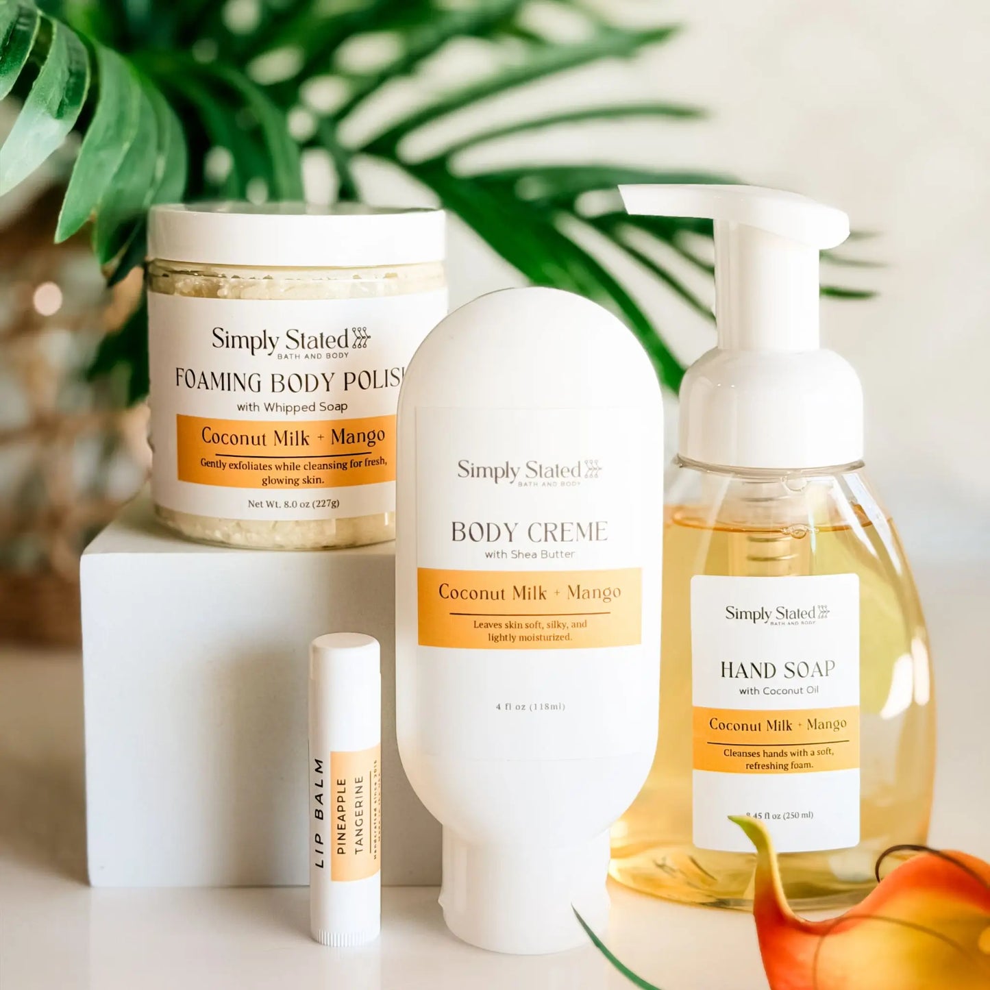 Simply Stated Self Care Starter Kit in Coconut Milk and Mango — foaming body polish, body creme, foaming hand soap, and Pineapple Tangerine lip balm, handcrafted in Colorado