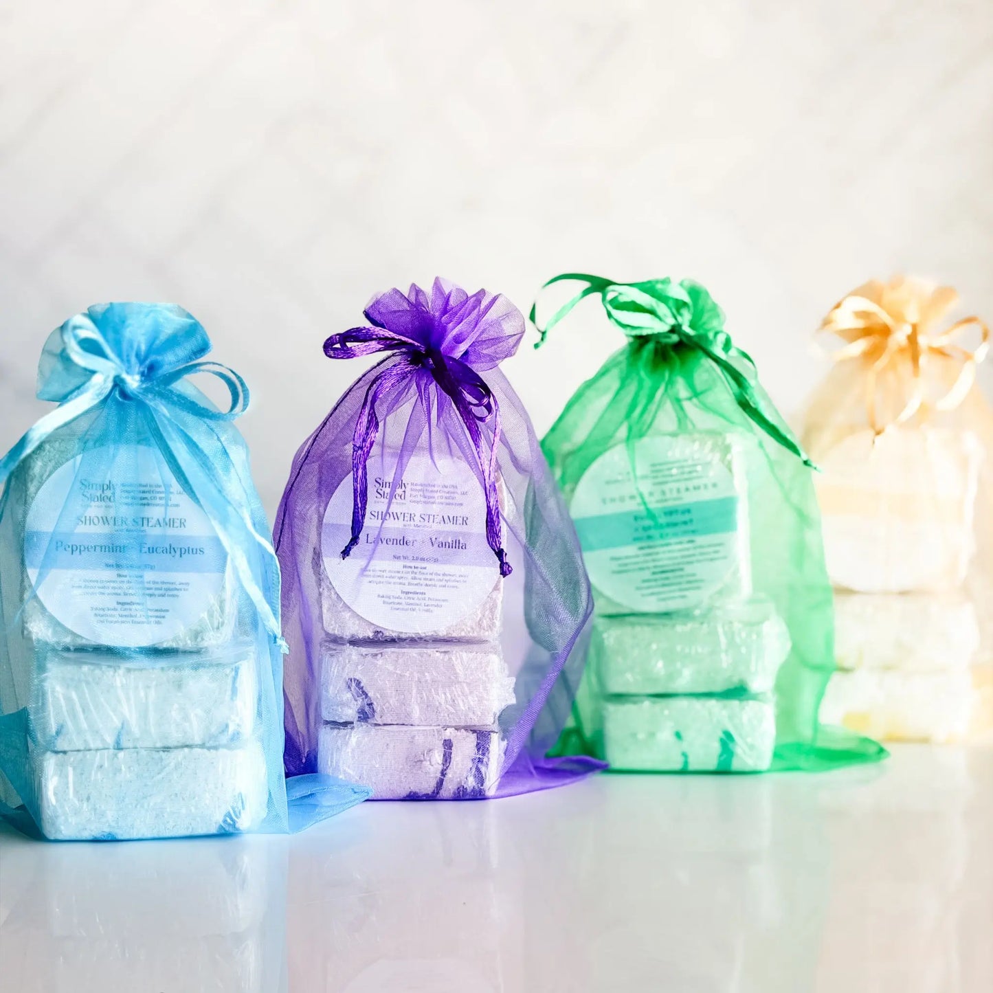 Simply Stated Shower Steamer 3-Packs in four scents — peppermint eucalyptus, lavender vanilla, eucalyptus spearmint, and tangerine citrus, handcrafted in Colorado