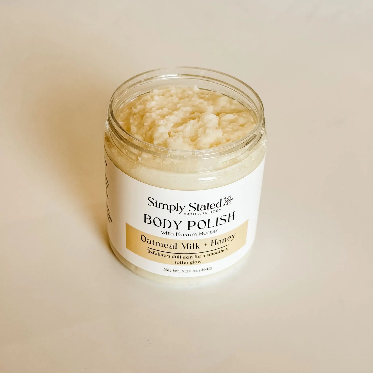 Simply Stated Bath and Body Oatmeal Milk + Honey Body Polish jar open, showing grainy sugar scrub texture.