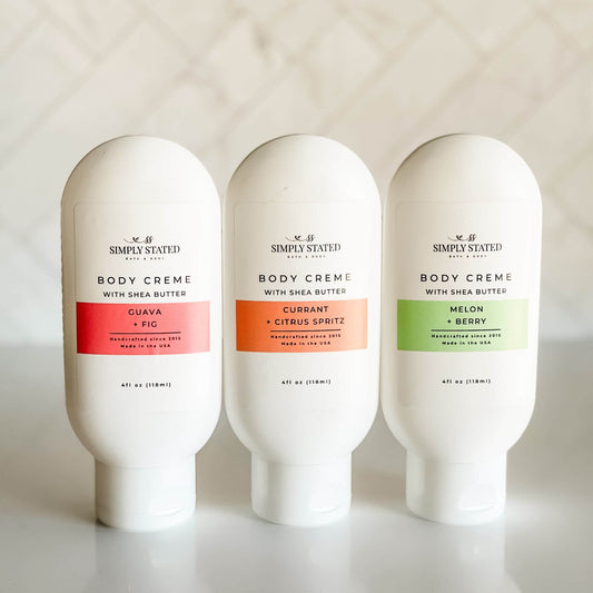 Group image of Simply Stated’s Summer Exclusive Scent of the Month Body Crèmes, arranged with seasonal labels including Guava Fig, Currant Citrus Spritz, and Melon Berry.