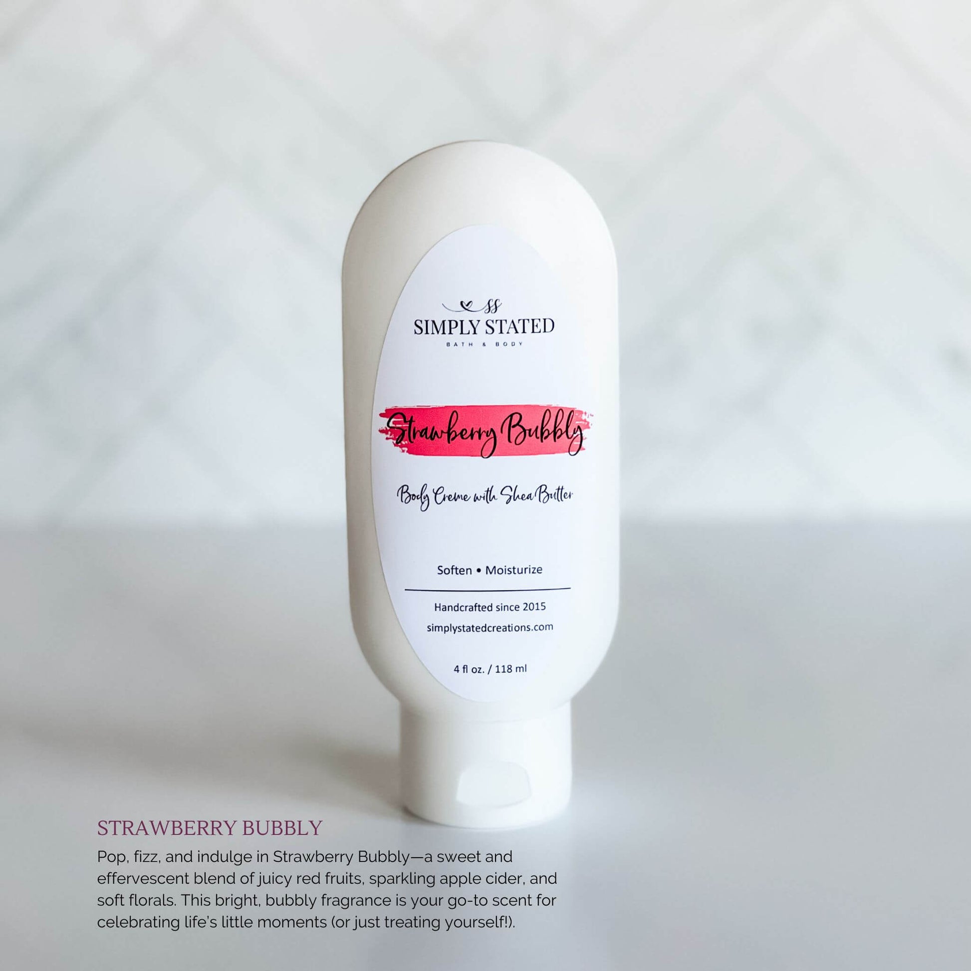 Simply Stated Bath & Body Strawberry Bubbly Body Creme bottle, a creamy shea butter moisturizer with a bright pink label, displayed on a soft white background.