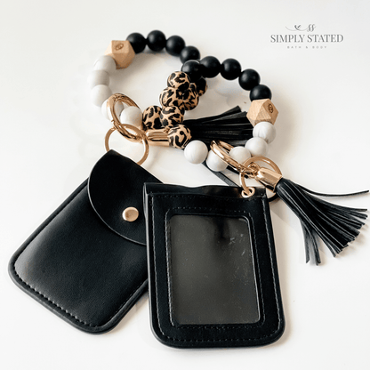 Card Case in Black. Includes silicone beaded bracelet keychain (white marble, solid black, and leopard print) and black tassle