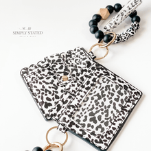 Card Wallet in black and white leopard print. Includes silicone beaded keychain (black and leopard print) and leopard print tassle