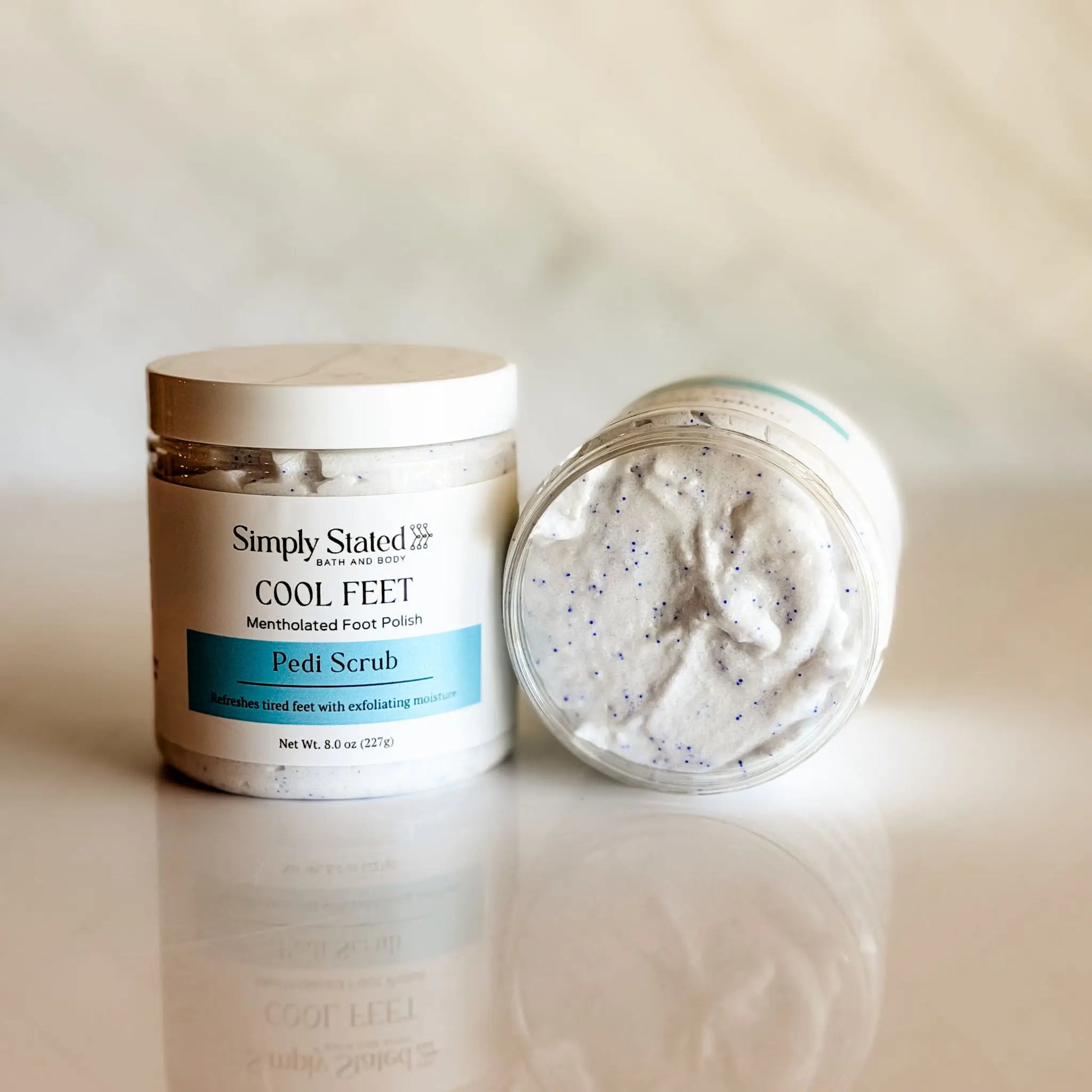 Simply Stated Cool Feet Pedi Scrub jar open showing white foaming scrub texture — mentholated foot polish with cocoa butter and shea butter, made in small batches in Colorado
