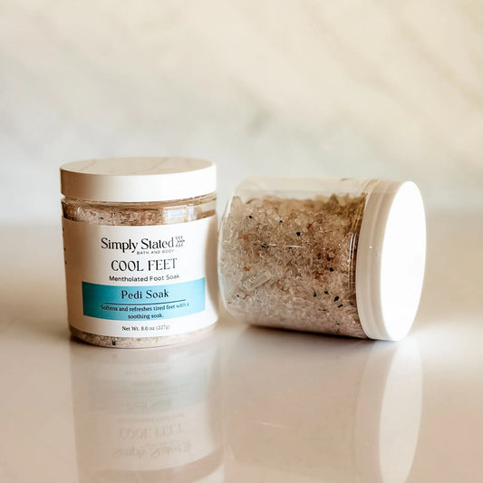 Simply Stated Cool Feet Pedi Soak jar open showing mineral salt crystal texture — mentholated foot soak with magnesium sulfate and activated charcoal, handcrafted in small batches in Colorado