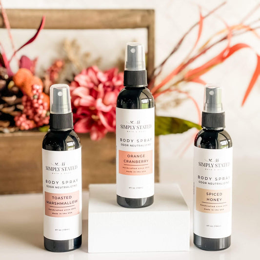 Simply Stated Fall Body Spray Collection in front of fall floral arrangement