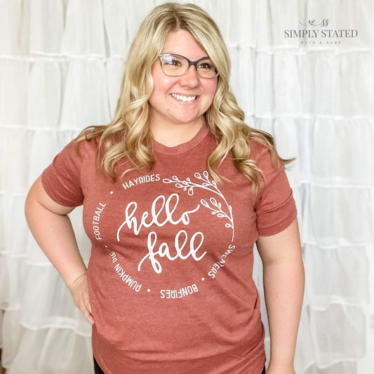Graphic T-Shirt in color Brick that says Hello Fall: Sweaters, Bonfires, Pumpkin Pie, Football, Hayrides