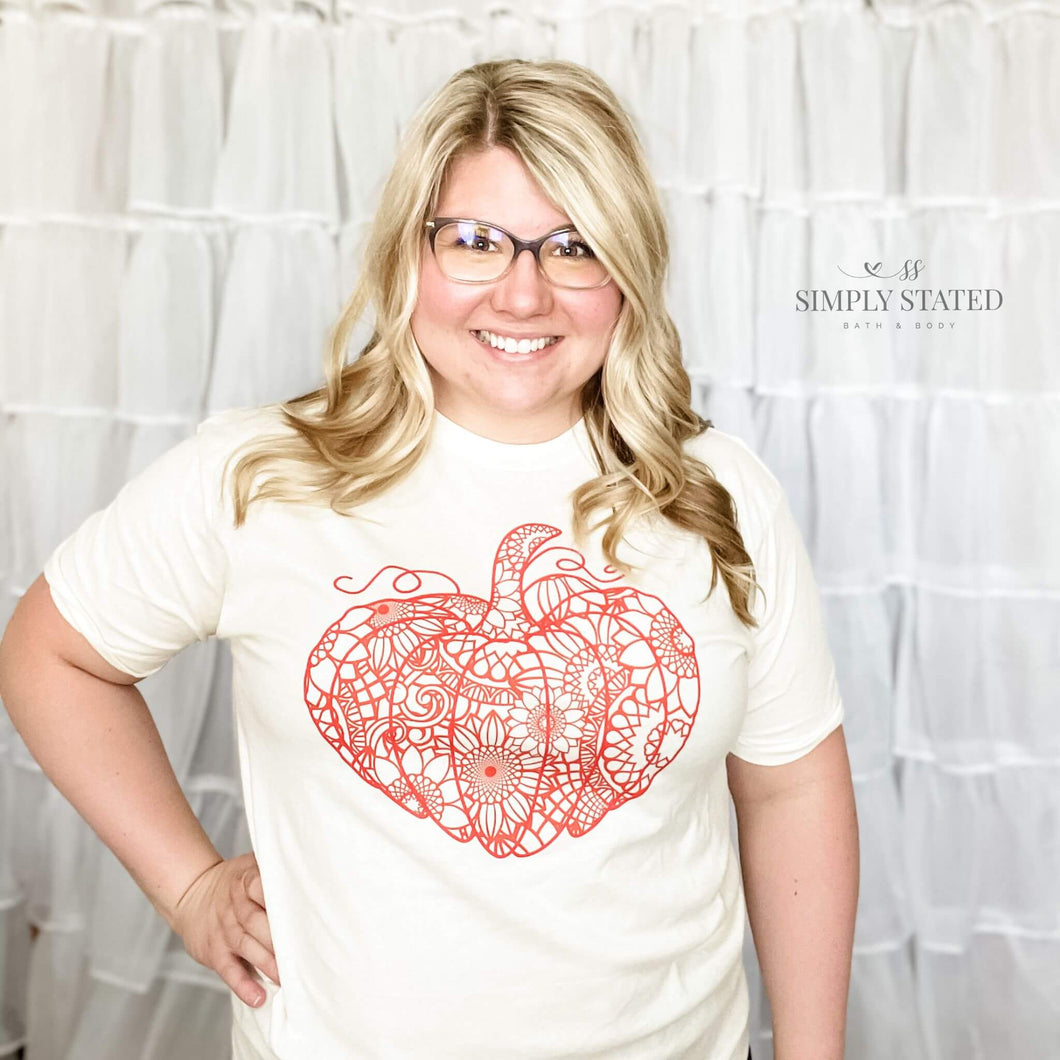 Graphic T-Shirt in a cream, natural color. The design is a large pumpkin with whimsy sunflowers for the inside pattern.