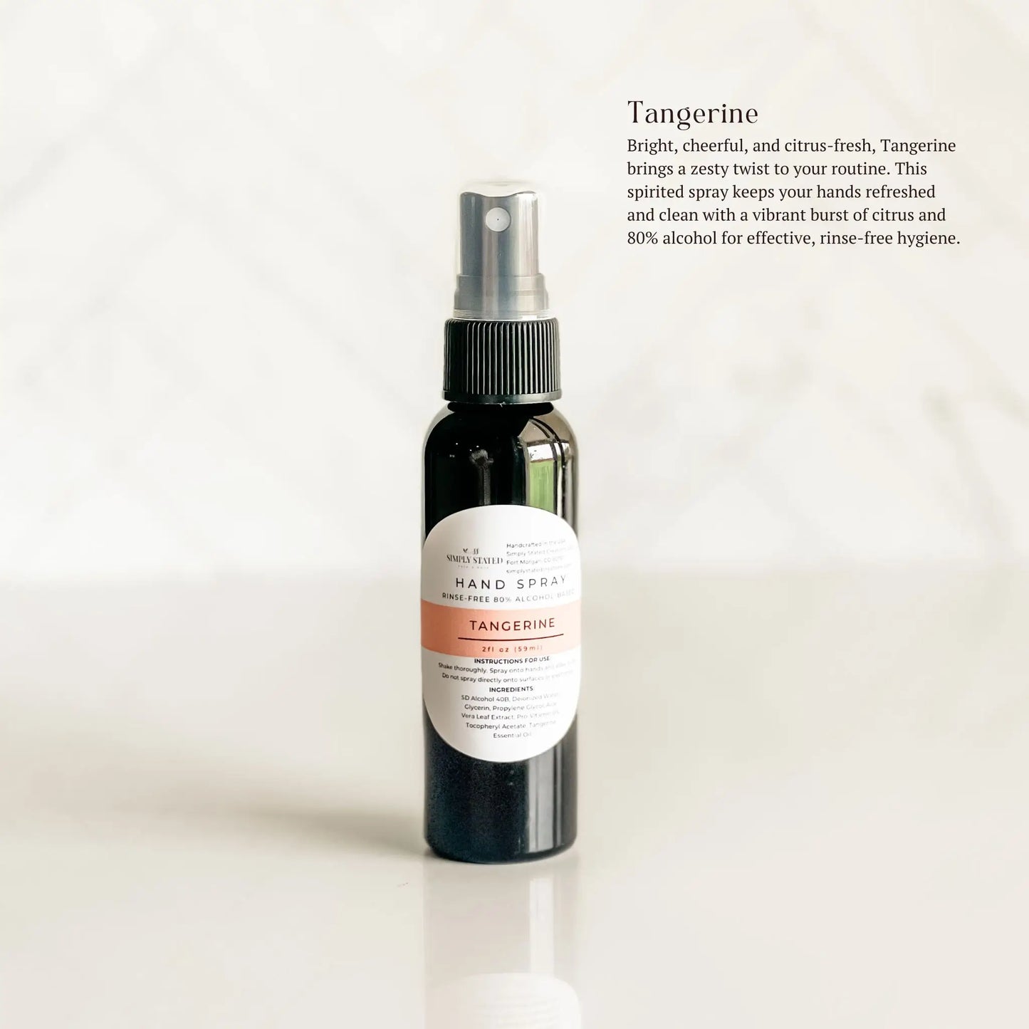 Hand spray bottle with tangerine scent on a white background