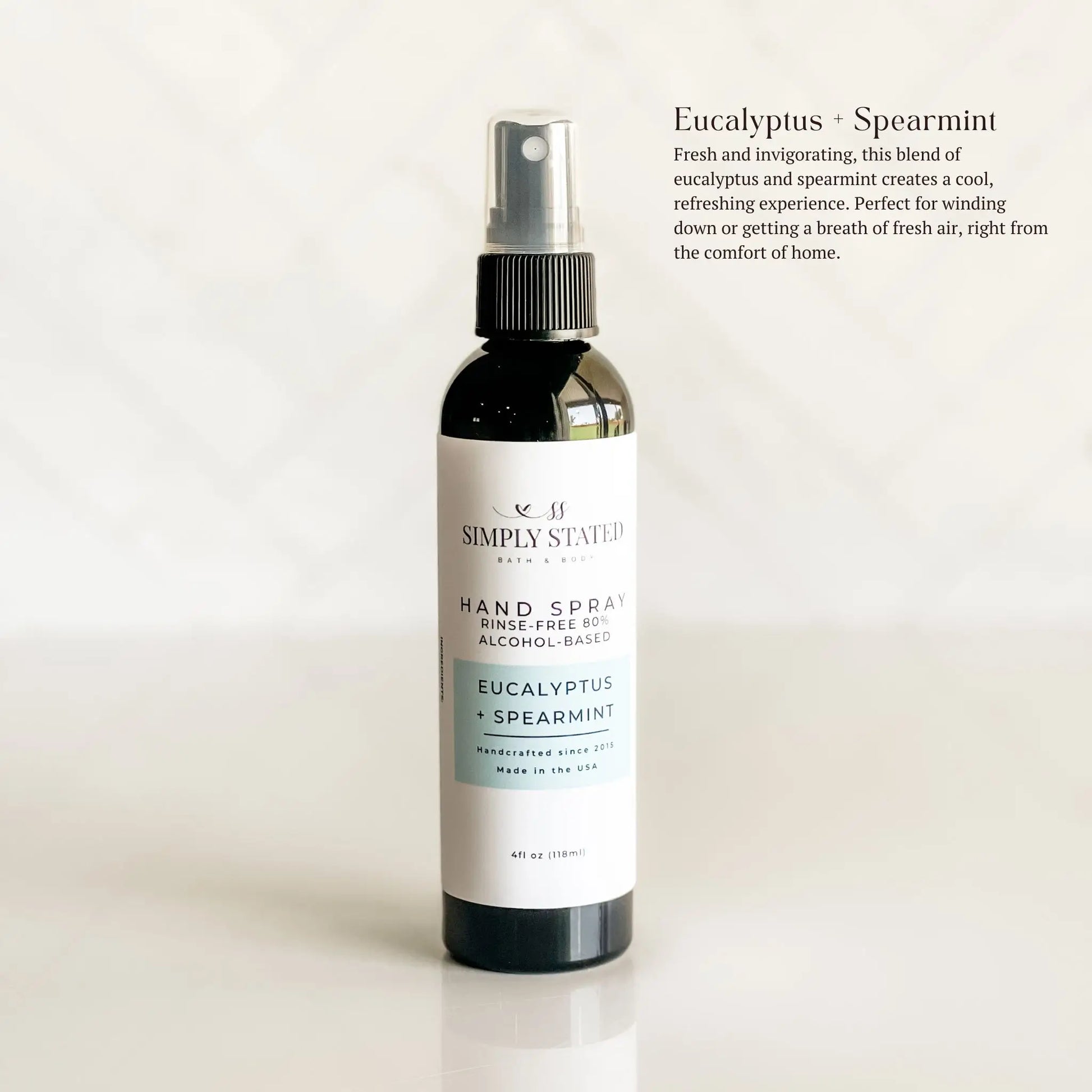 Hand spray bottle labeled 'Simply Stationery' with eucalyptus and spearmint scent on a light background.