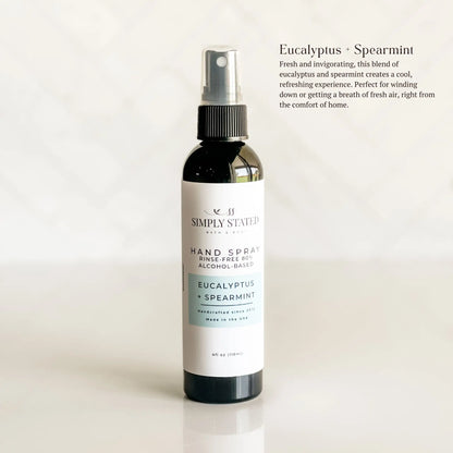 Hand spray bottle labeled 'Simply Stationery' with eucalyptus and spearmint scent on a light background.