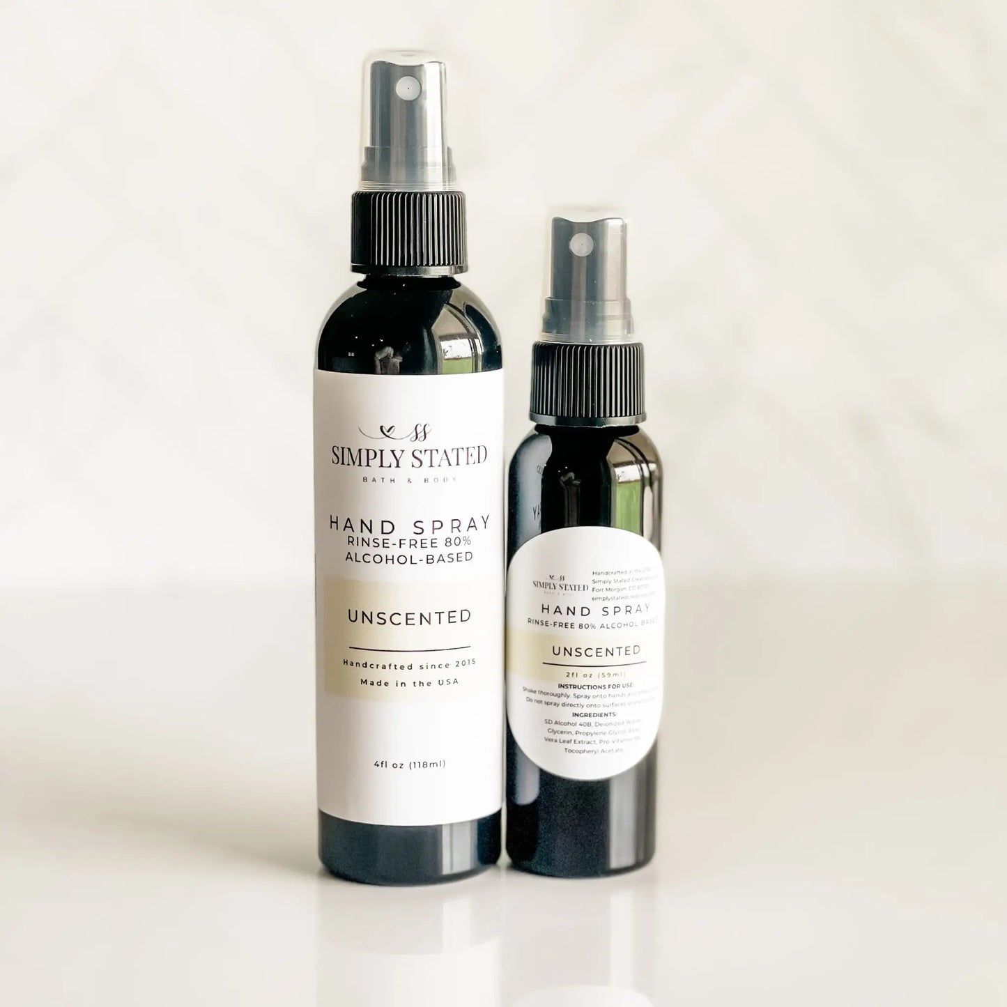 Two bottles of Simply Stated hand spray on a white background