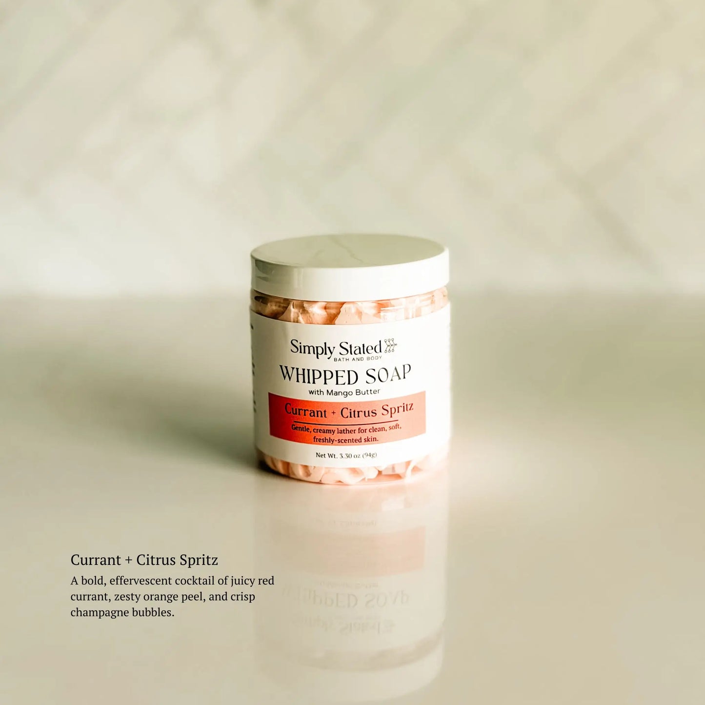Jar of whipped soap with a label on a beige background