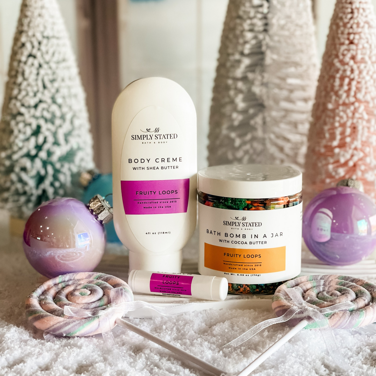Simply Stated fruity loops body creme, bath bomb in a jar and lip balm with pastel trees, lollipops and ornaments