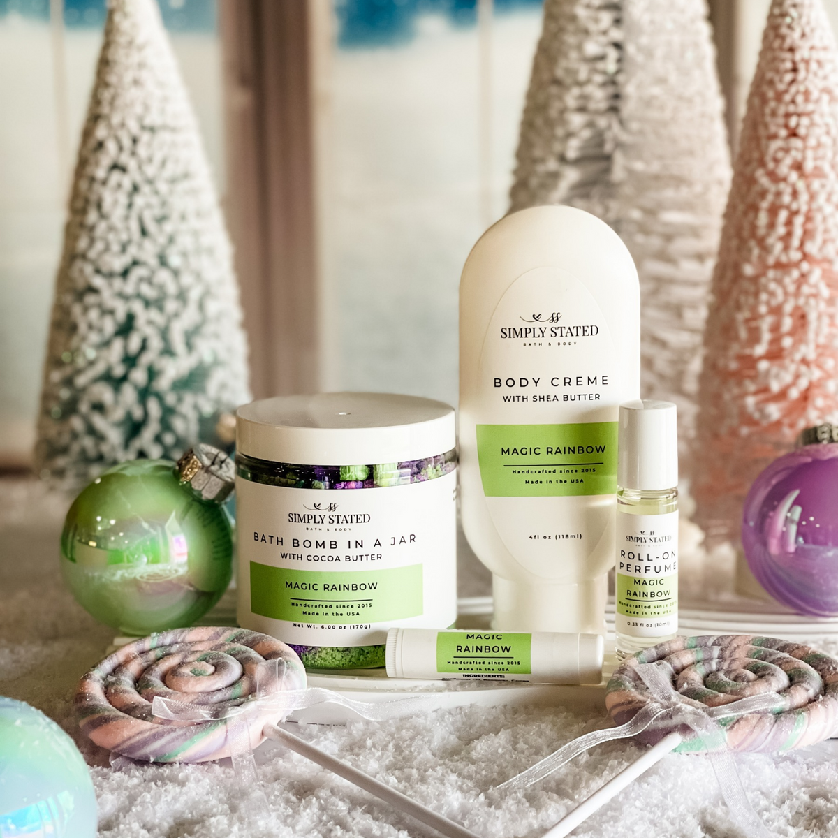 Simply Stated magic rainbow bath bomb jar, body creme, lip balm and roll-on perfume with pastel trees and ornaments