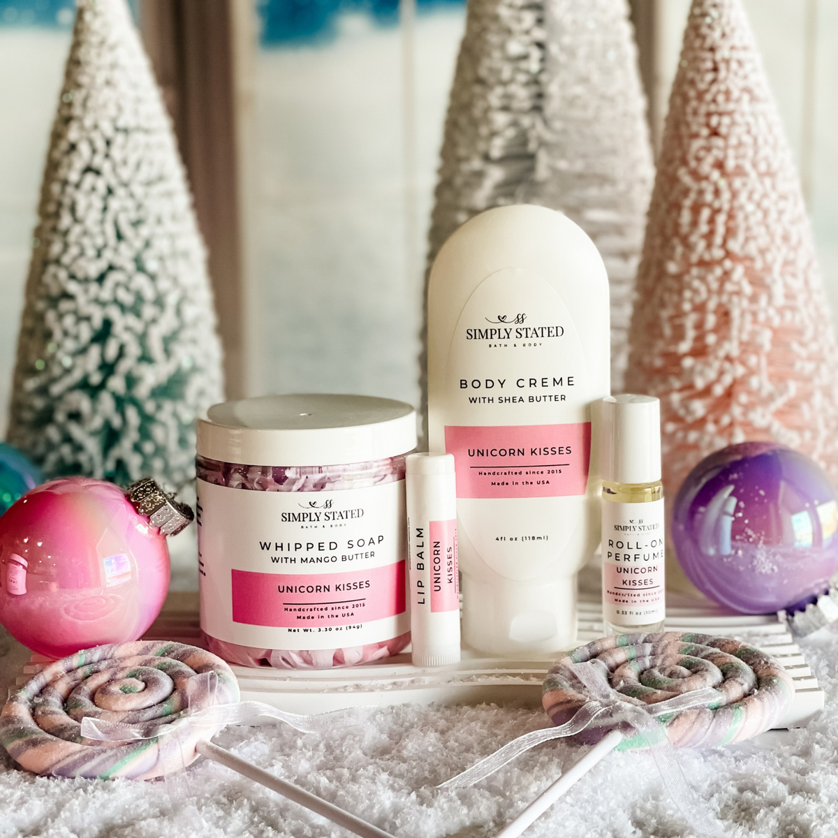 Simply Stated unicorn kisses whipped soap, body creme, lip balm and roll-on perfume with pastel trees and ornaments