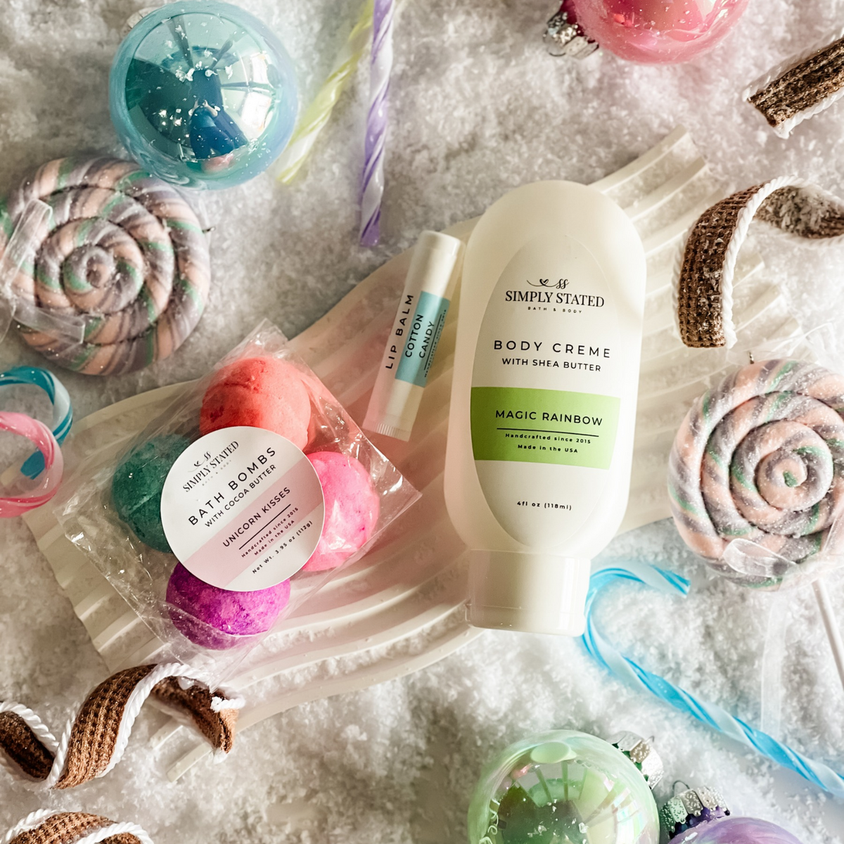 Simply Stated unicorn kisses bath bombs, cotton candy lip balm and magic rainbow body creme with candy and snow