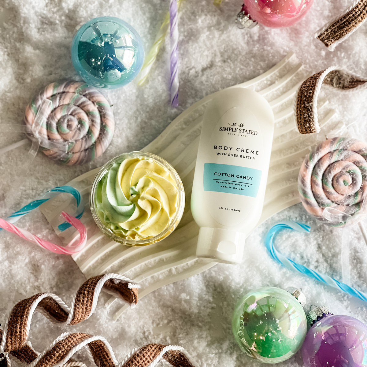 Simply Stated Cotton Candy Body Creme with shea butter and whipped soap, pastel candy and ornament snow scene.
