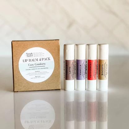 Lip balm 4-pack with a cardboard box labeled 'Cozy Comforts' on a reflective surface.