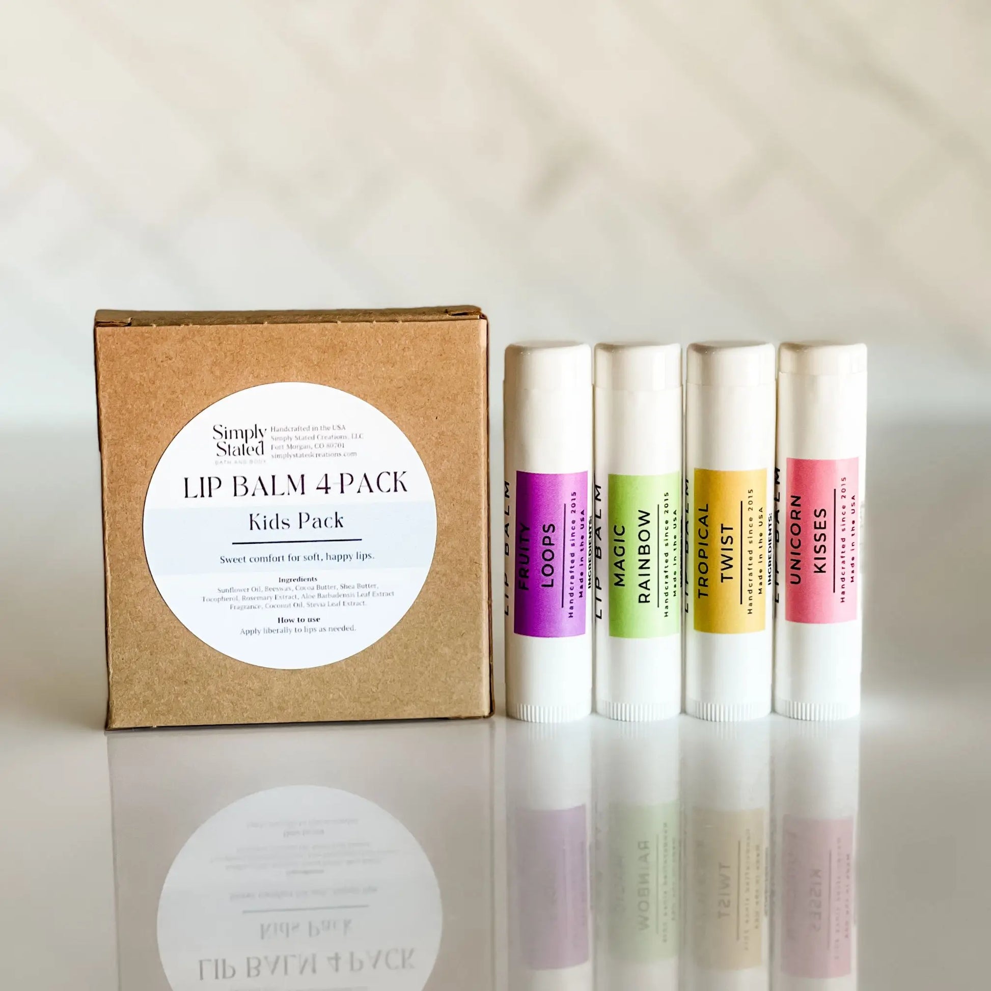 Lip balm 4-pack with a cardboard box on a reflective surface labeled 'Kids Pack.'