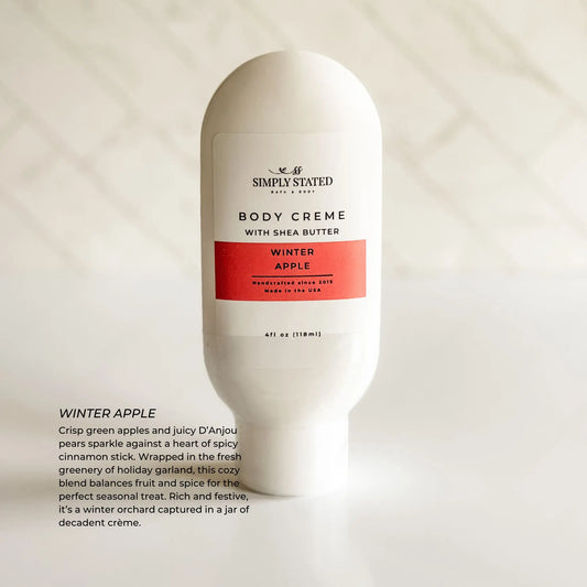 Body crème bottle labeled 'Simply Stated' with 'Winter Apple' flavor on a light background