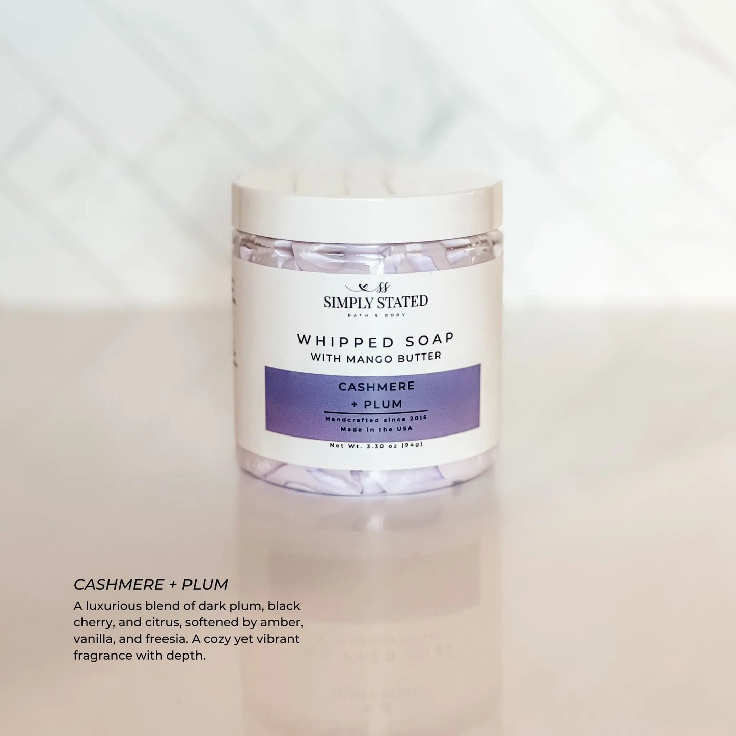 Jar of whipped soap with cashmere and plum fragrance on a white background