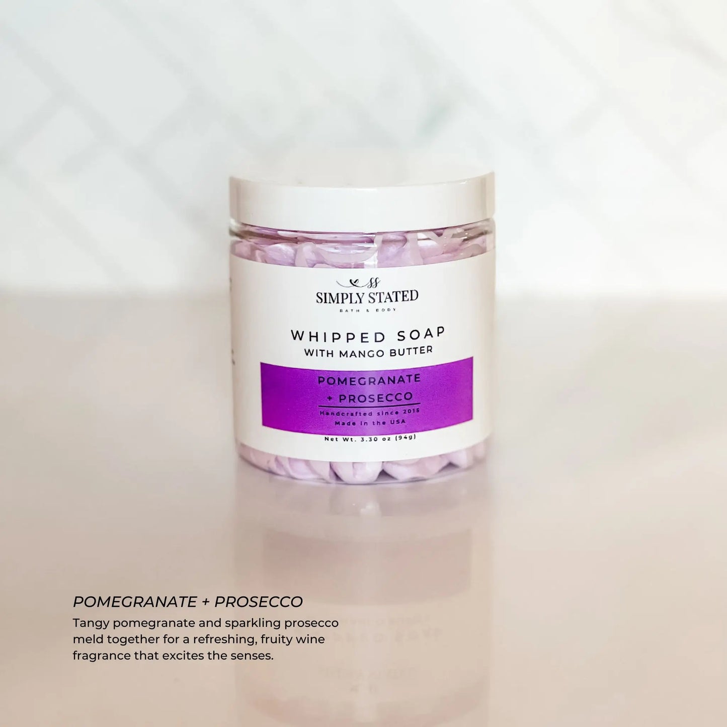 Jar of whipped soap with pomegranate and prosecco fragrance on a light background