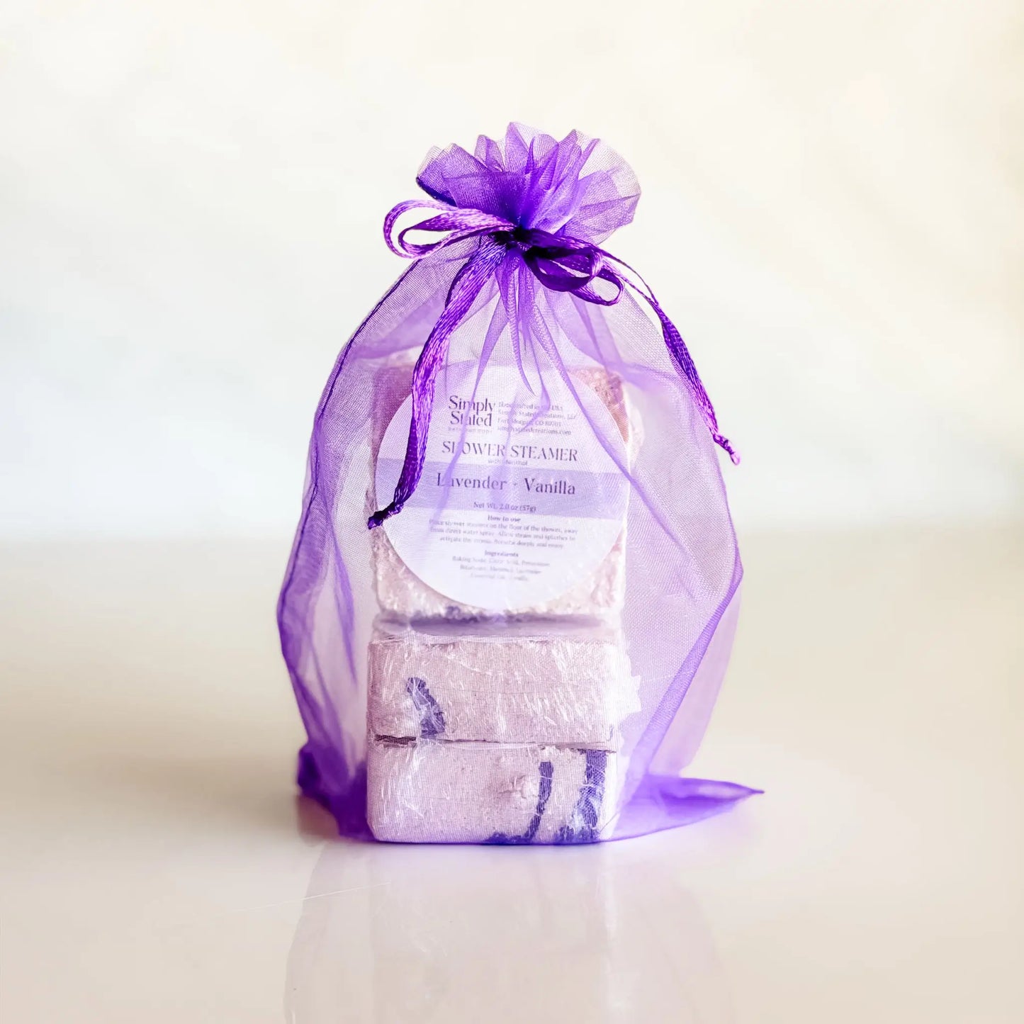 Simply Stated Lavender Vanilla Shower Steamer 3-Pack in purple organza bag — gift-ready menthol steamers handcrafted in Colorado