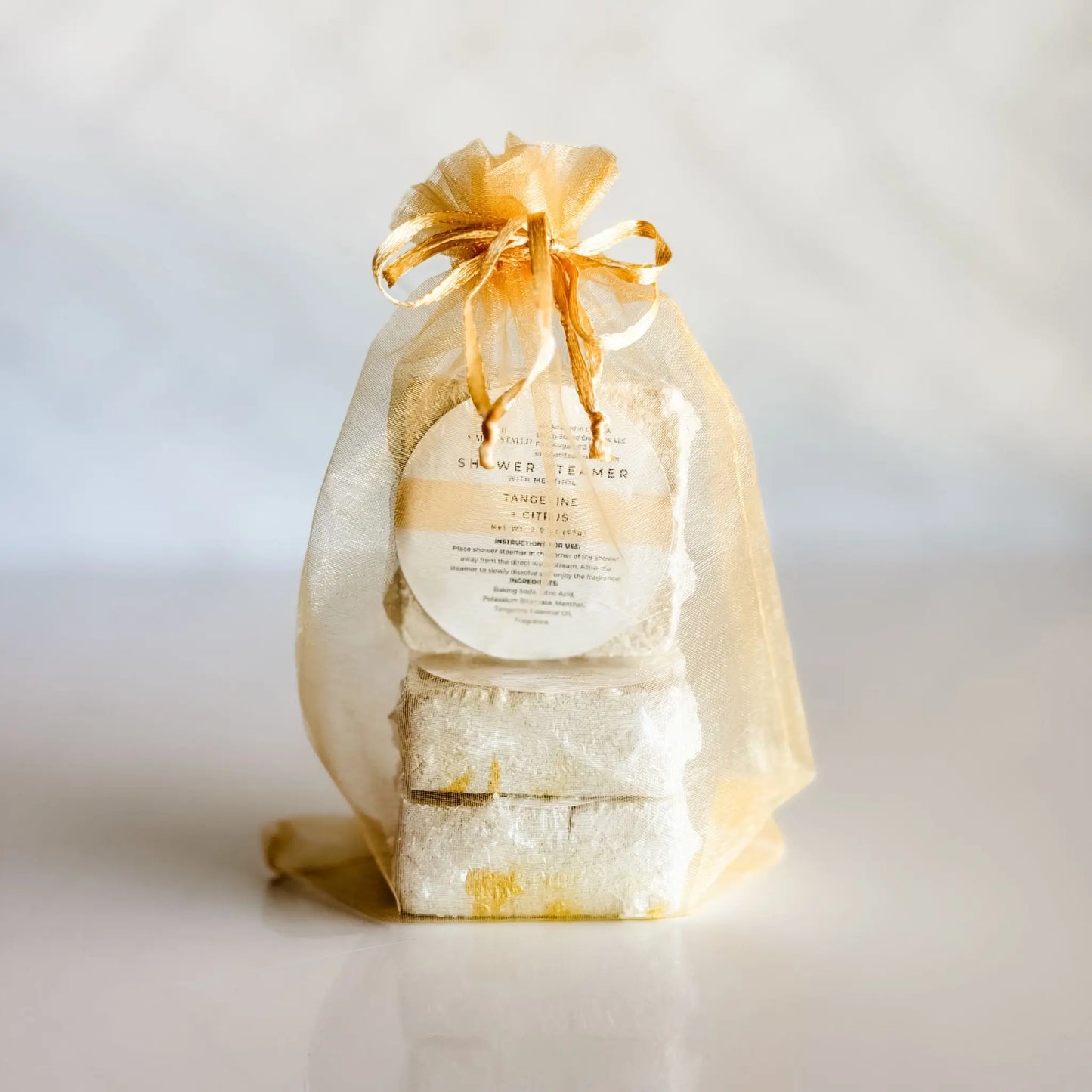 Simply Stated Tangerine Citrus Shower Steamer 3-Pack in gold organza bag — gift-ready menthol steamers handcrafted in Colorado