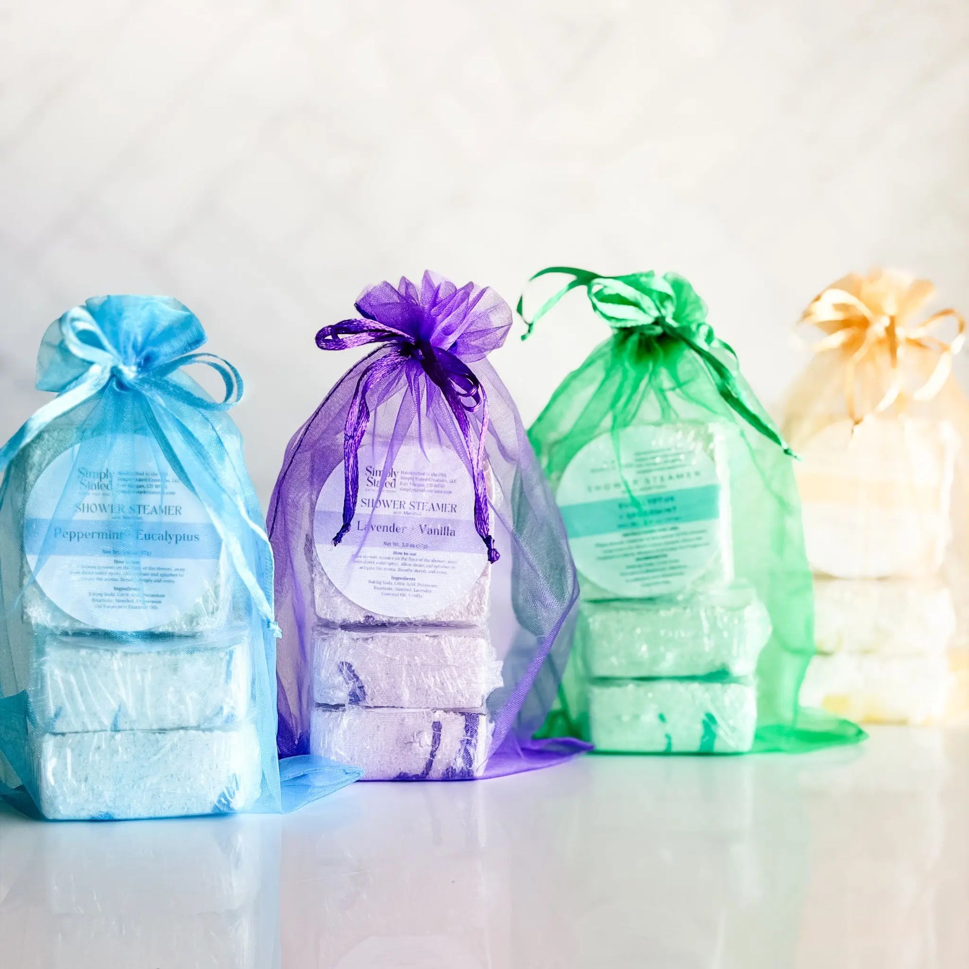 Simply Stated Shower Steamer 3-Packs in four scents — peppermint eucalyptus, lavender vanilla, eucalyptus spearmint, and tangerine citrus, handcrafted in Colorado