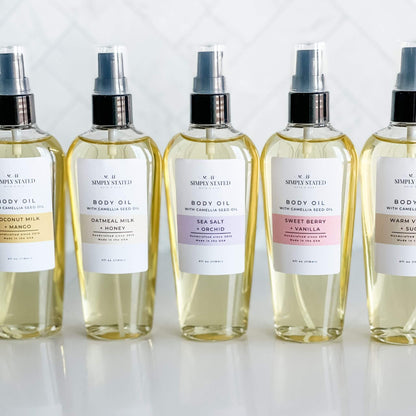 Simply Stated Bath & Body's complete Signature Body Oil collection in 4oz bottles, showcasing the Coconut Milk + Mango, Oatmeal Milk + Honey, Sea Salt + Orchid, Sweet Berry + Vanilla, and Warm Vanilla + Sugar fragrances for luxurious hydration.