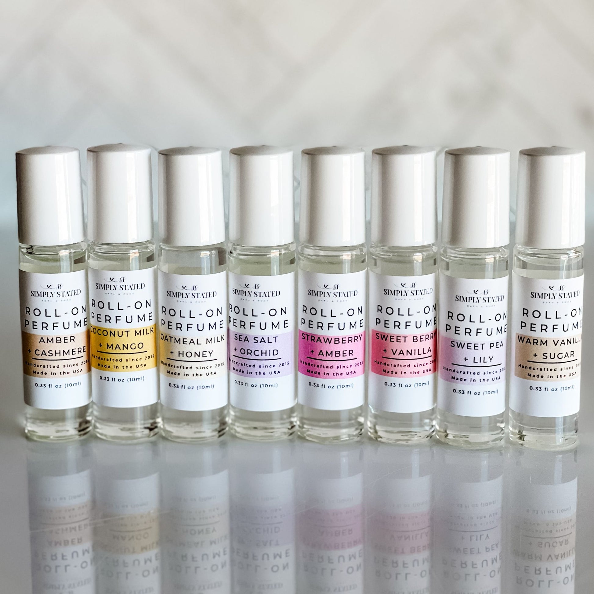 Simply Stated Signature Roll-On Perfume collection featuring elegant 10ml bottles in scents like Coconut Milk + Mango, Sea Salt + Orchid, Sweet Berry + Vanilla, and more. A handcrafted, compact fragrance collection for fresh, lasting aromas.