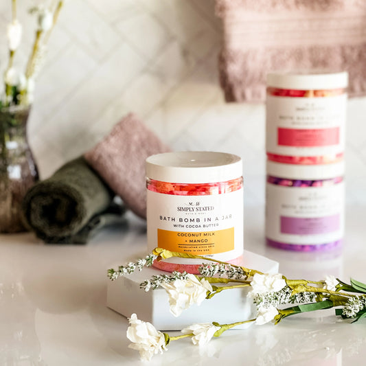 Bath bomb in a jar with decorative flowers on a marble surface