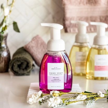 Hand soap bottle with floral arrangement on a table