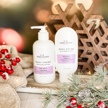 Simply Stated Sea Salt + Orchid Body Creme with shea butter, pump and tube sizes, with wooden snowflakes and berries.