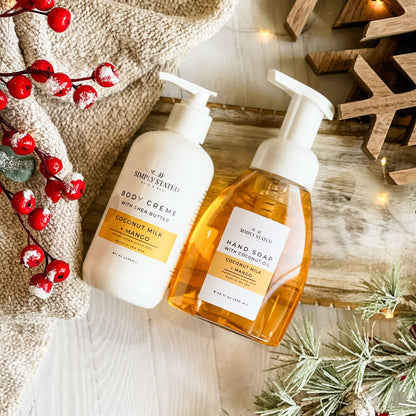 Simply Stated Coconut Milk + Mango Body Creme and Foaming Hand Soap duo, styled with berries and frosted pine.