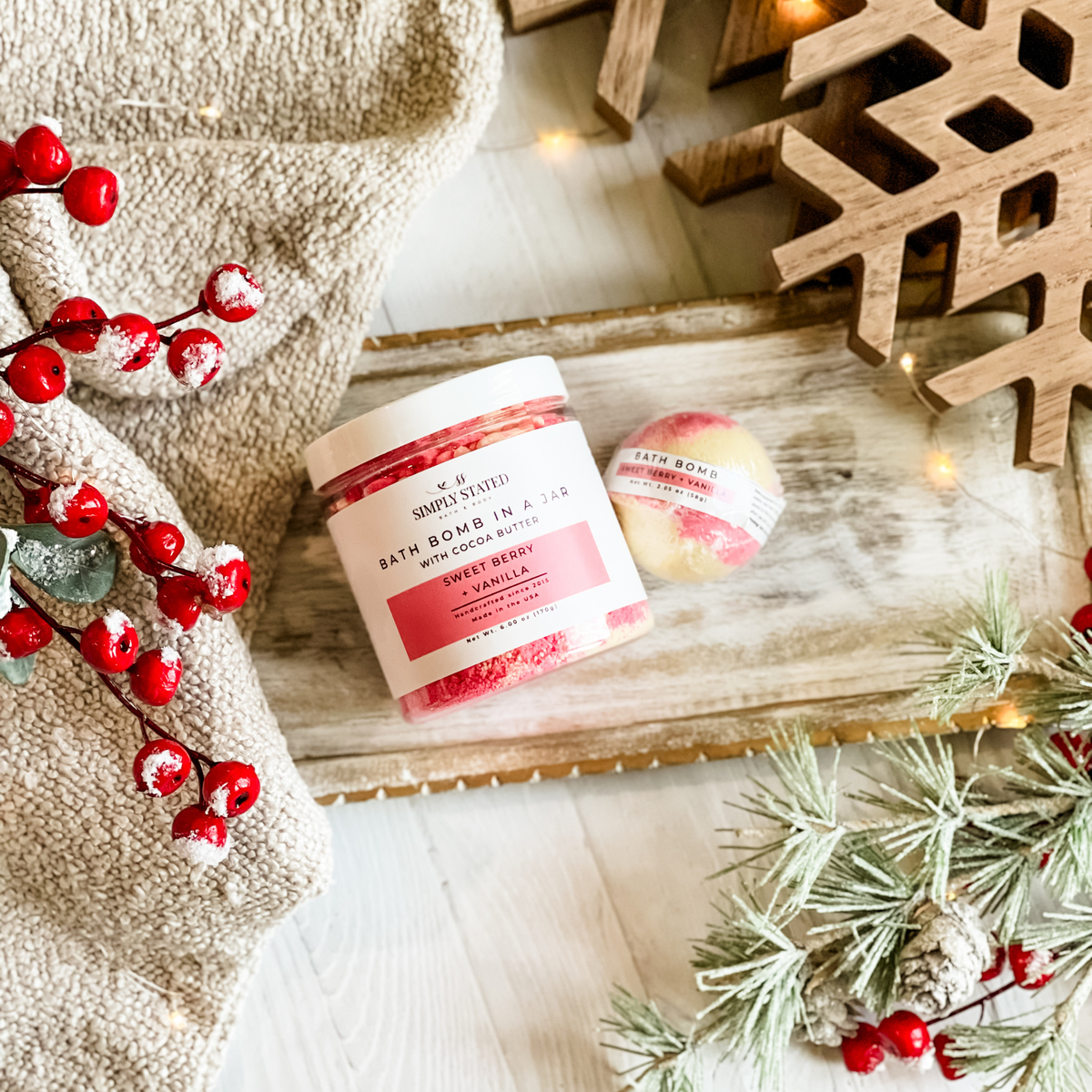 Simply Stated Sweet Berry + Vanilla Bath Bomb in a Jar with cocoa butter and a single bath bomb, with berries and pine.