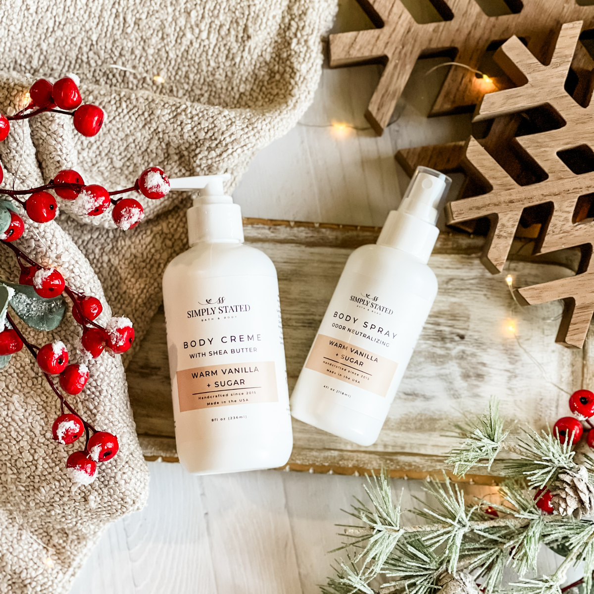 Simply Stated Warm Vanilla + Sugar  Body Creme and Body Spray duo, styled with berries and frosted pine