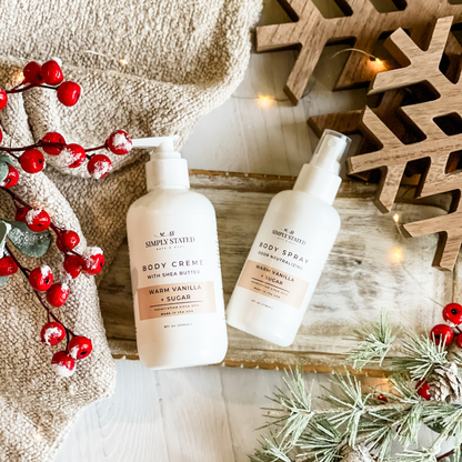Simply Stated Warm Vanilla + Sugar  Body Creme and Body Spray duo, styled with berries and frosted pine