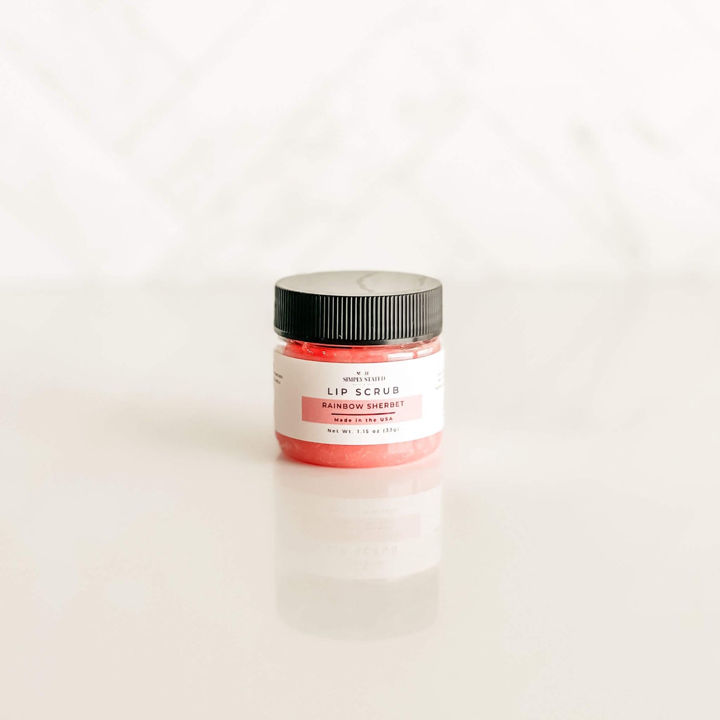 Simply Stated rainbow sherbet lip scrub in a bold red-pink hue, evoking the sweet, fruity essence of classic sherbet.