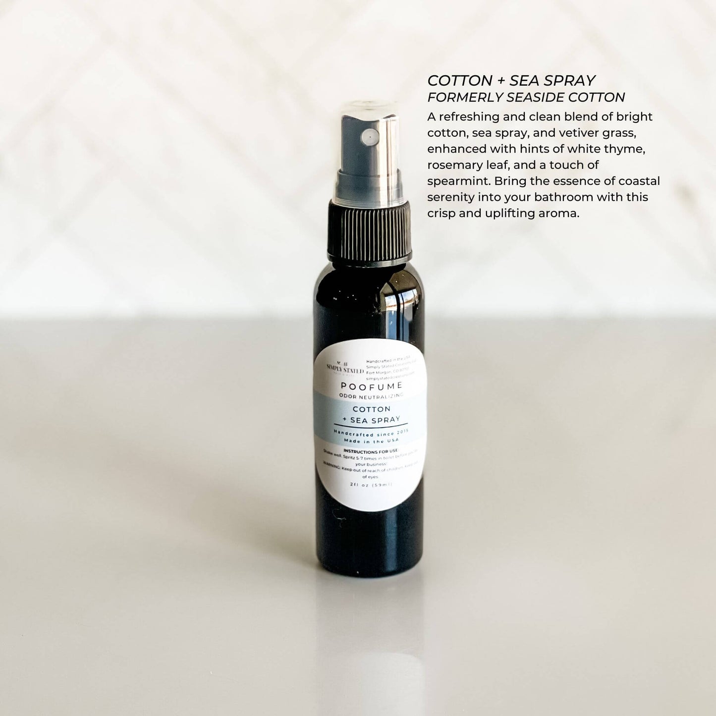 Black spray bottle labeled 'Cotton + Sea Spray' on a white background