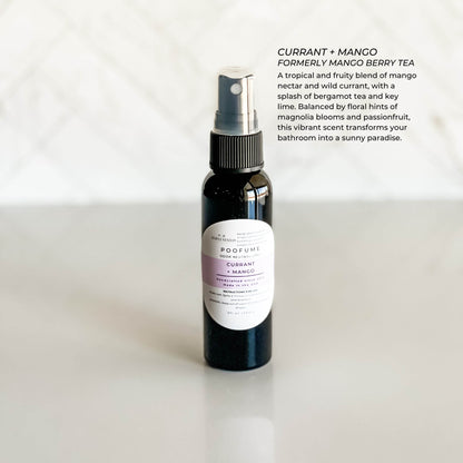 Black spray bottle labeled 'Currant + Mango' on a white background