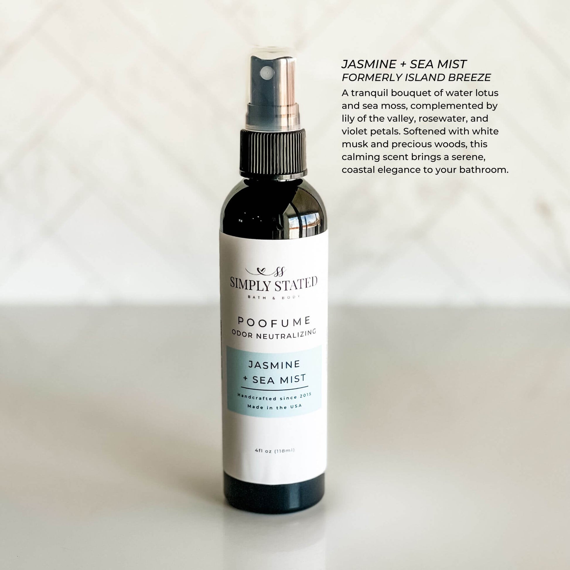 Bottle of Simply Stated poofume labeled 'Jasmine + Sea Mist' on a light background