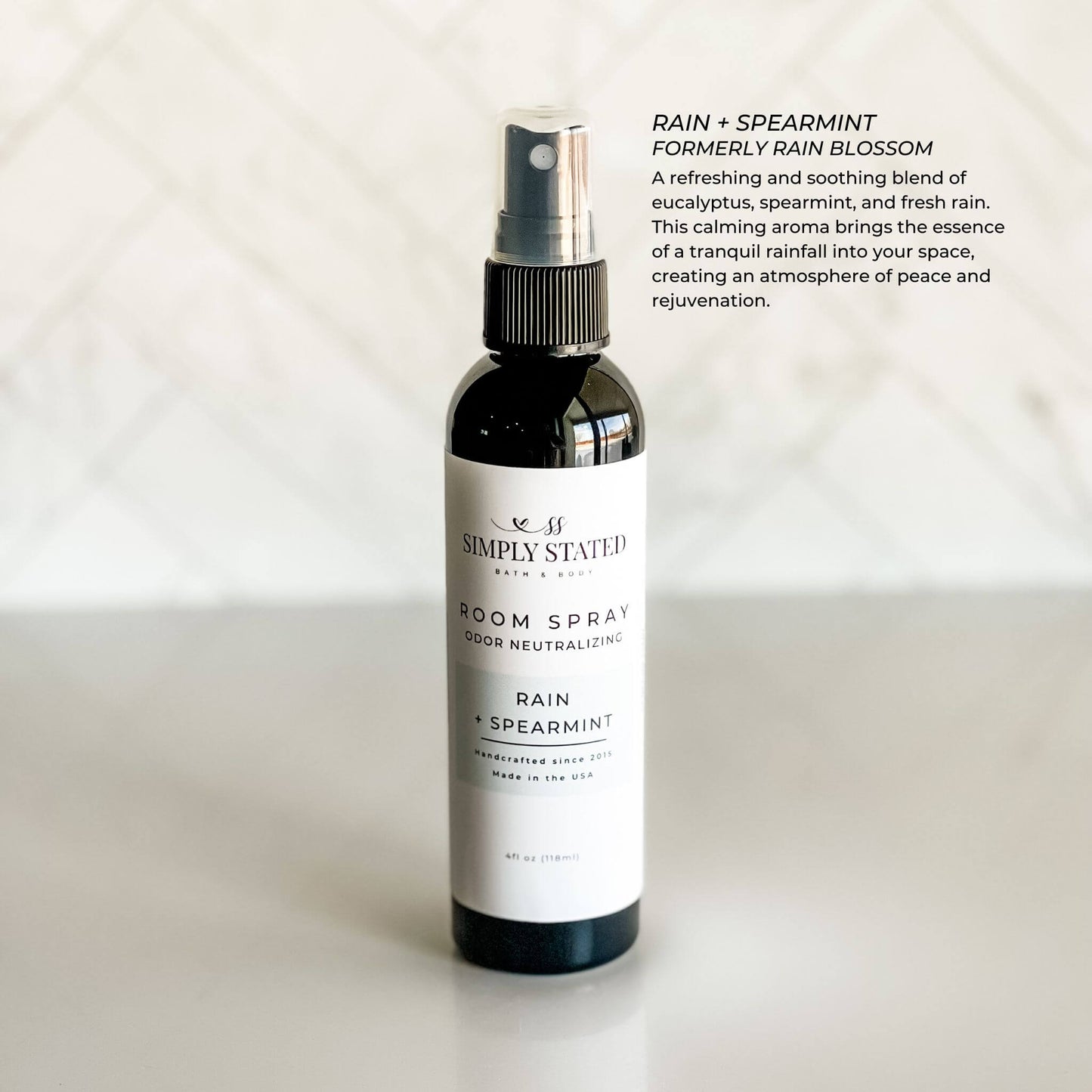 Room spray bottle labeled 'Rain + Spearmint' by Simply Stated on a light background