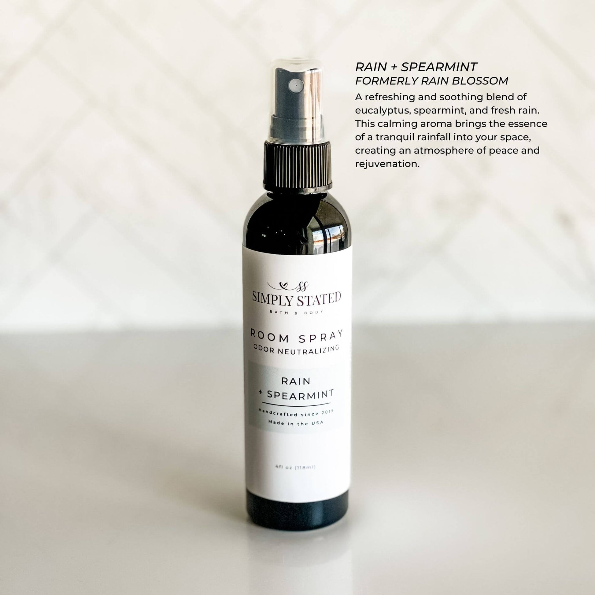 Room spray bottle labeled 'Rain + Spearmint' by Simply Stated on a light background