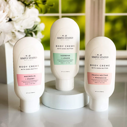 Spring Floral Orchard Body Creme Collection, showcasing the three scent variants—Magnolia + Peony, Peach Nectar + Prosecco, and Verbena + Lemon—with a bright spring floral background.